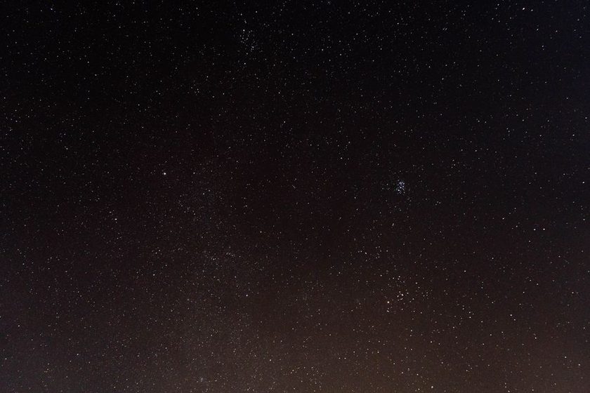 Bright satellite streak crossing a dusk sky